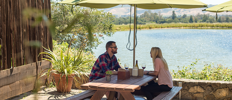 Couple sitting on a patio chatting and drinking wine