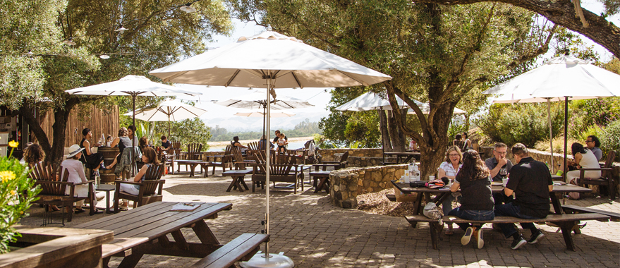 Picnic tables with umbrellas and flowers in foreground