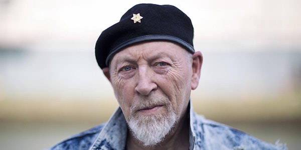 Older man with a gray goatee wearing a beret