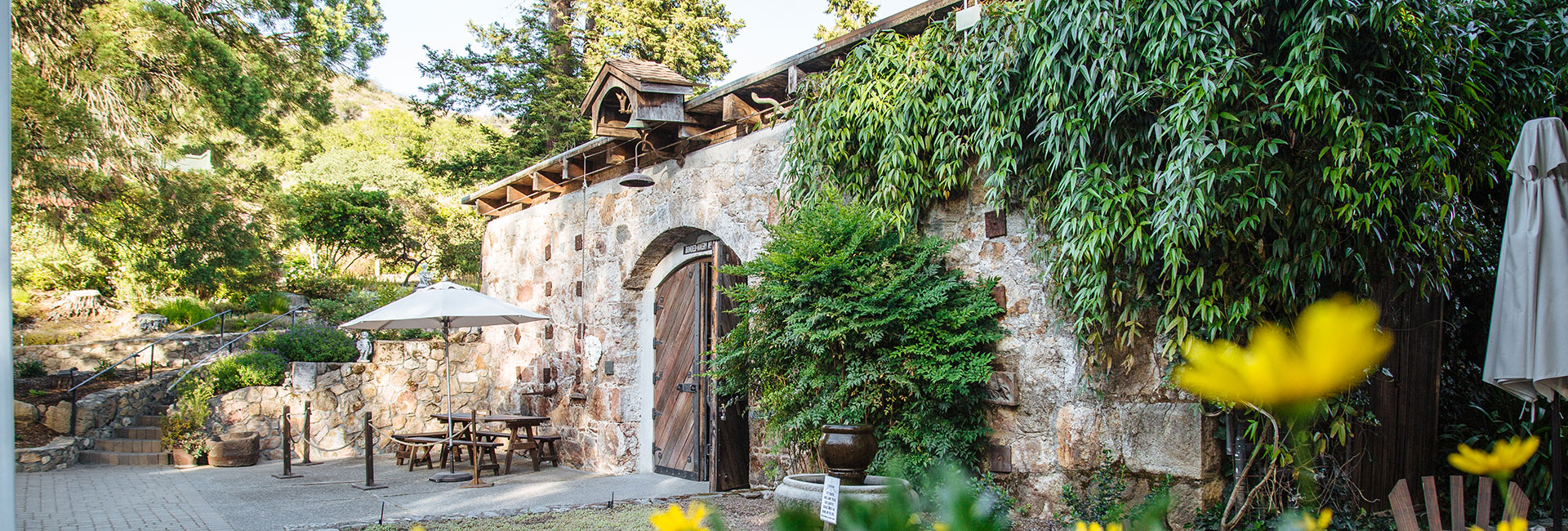 Stone building with arched entrance and wooden doors to Gundlach Bundschu Winery